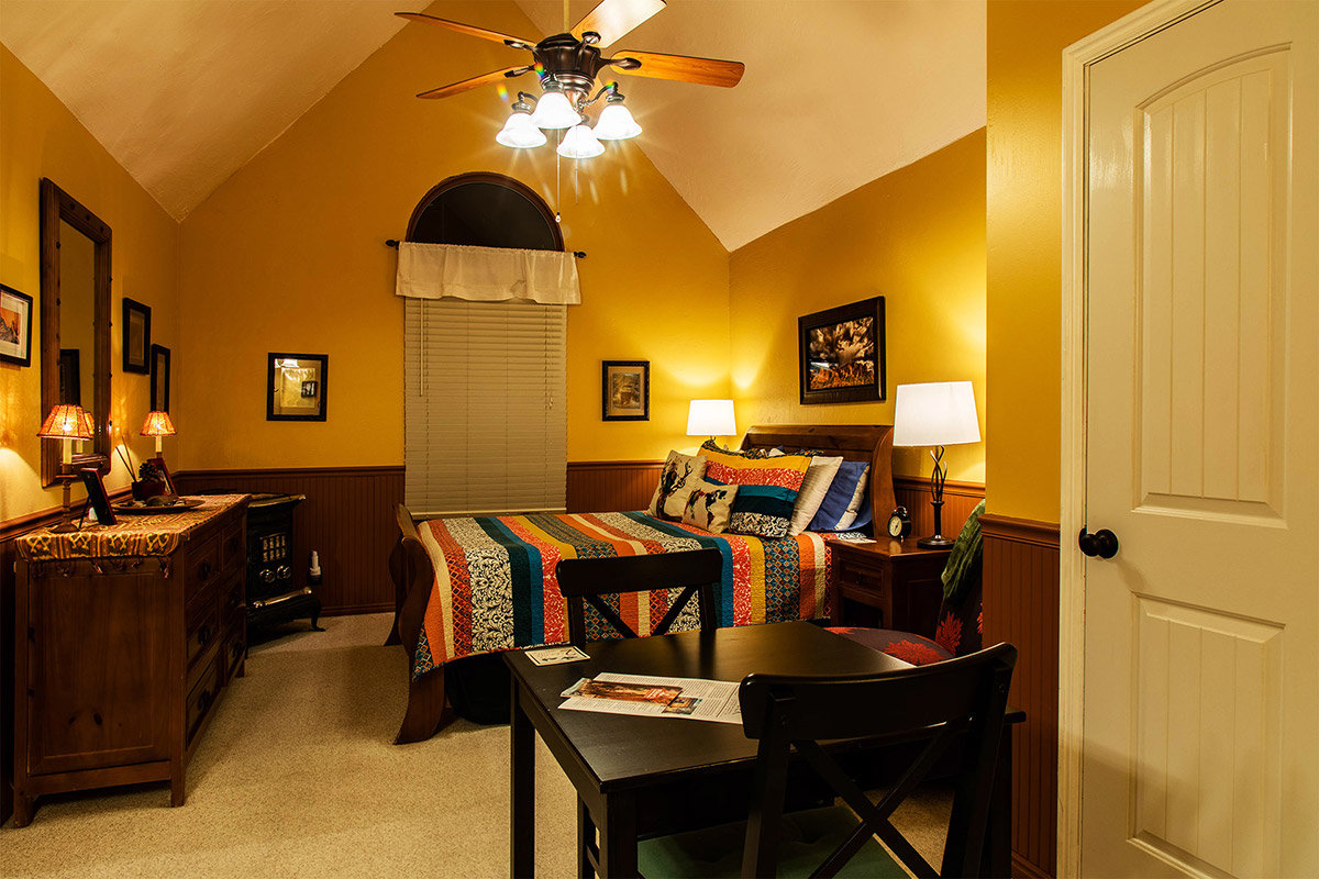 Warmly-lit bedroom in bed and breakfast with yellow walls