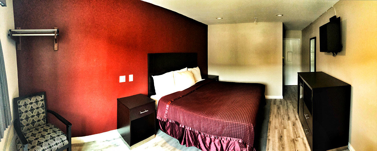 Hotel room with red accent wall and king size bed