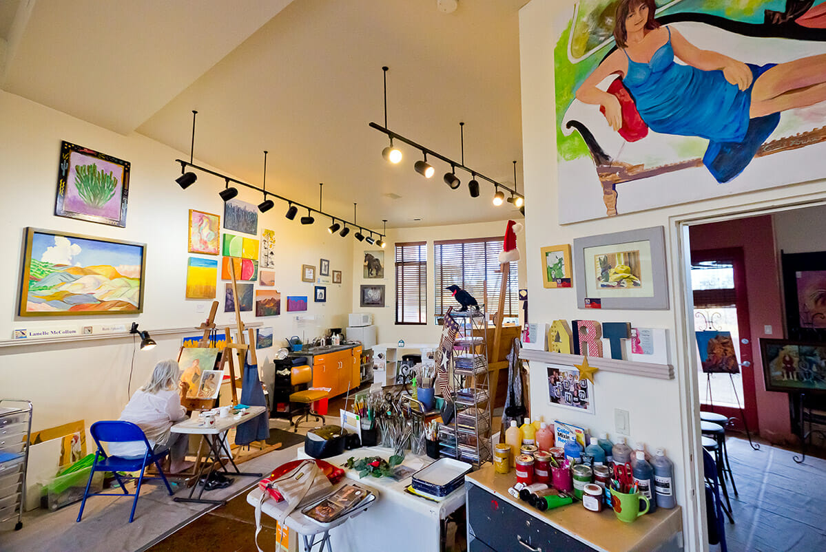 Female artist paining inside of gallery.