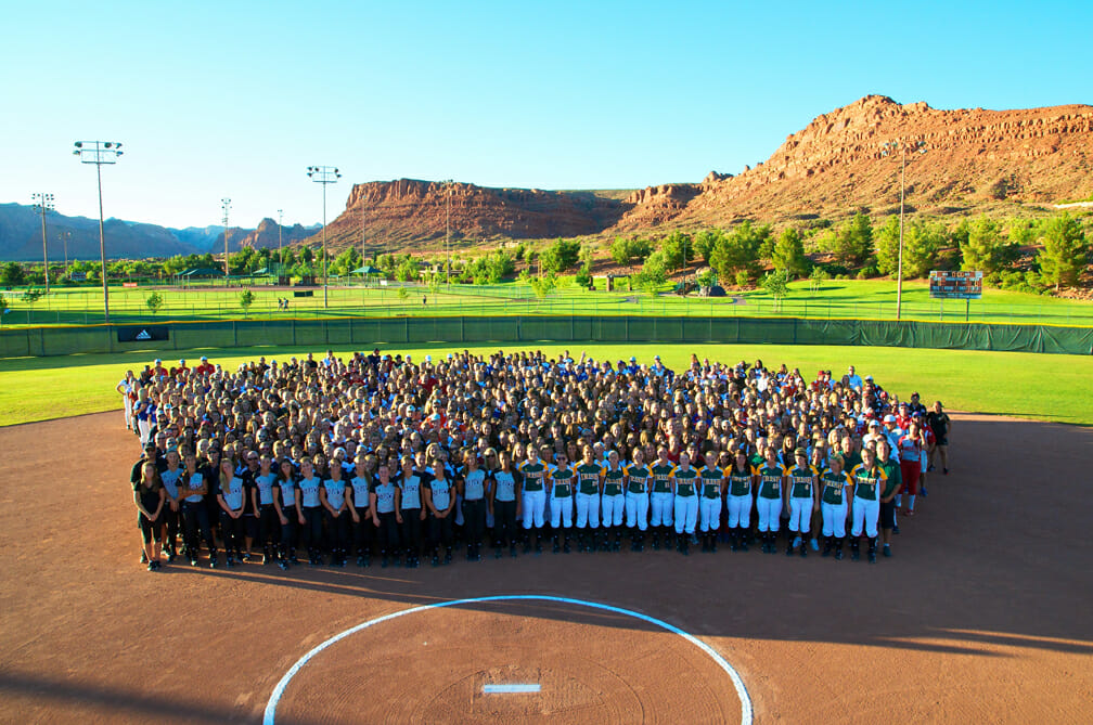 Large group of young female softball players on field