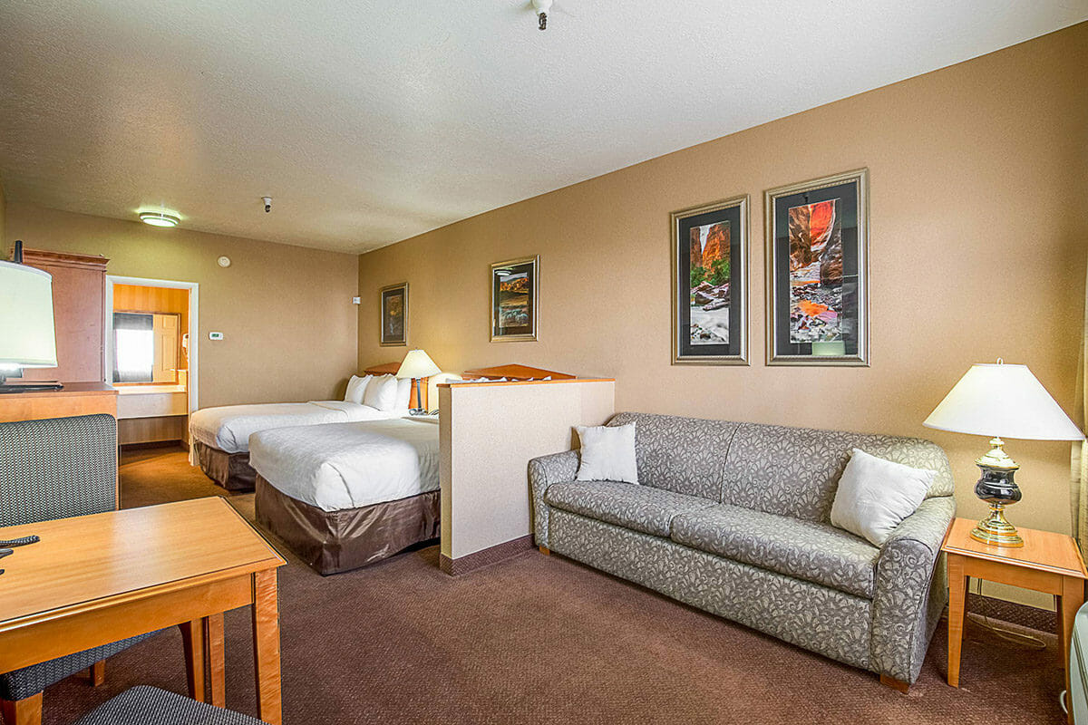 Hotel bedroom with two queen beds and sofa