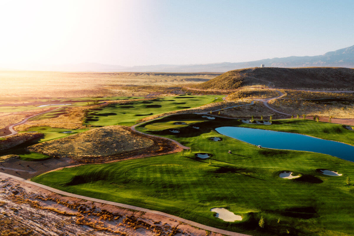 Aerial view of golf course with pond at sunrise