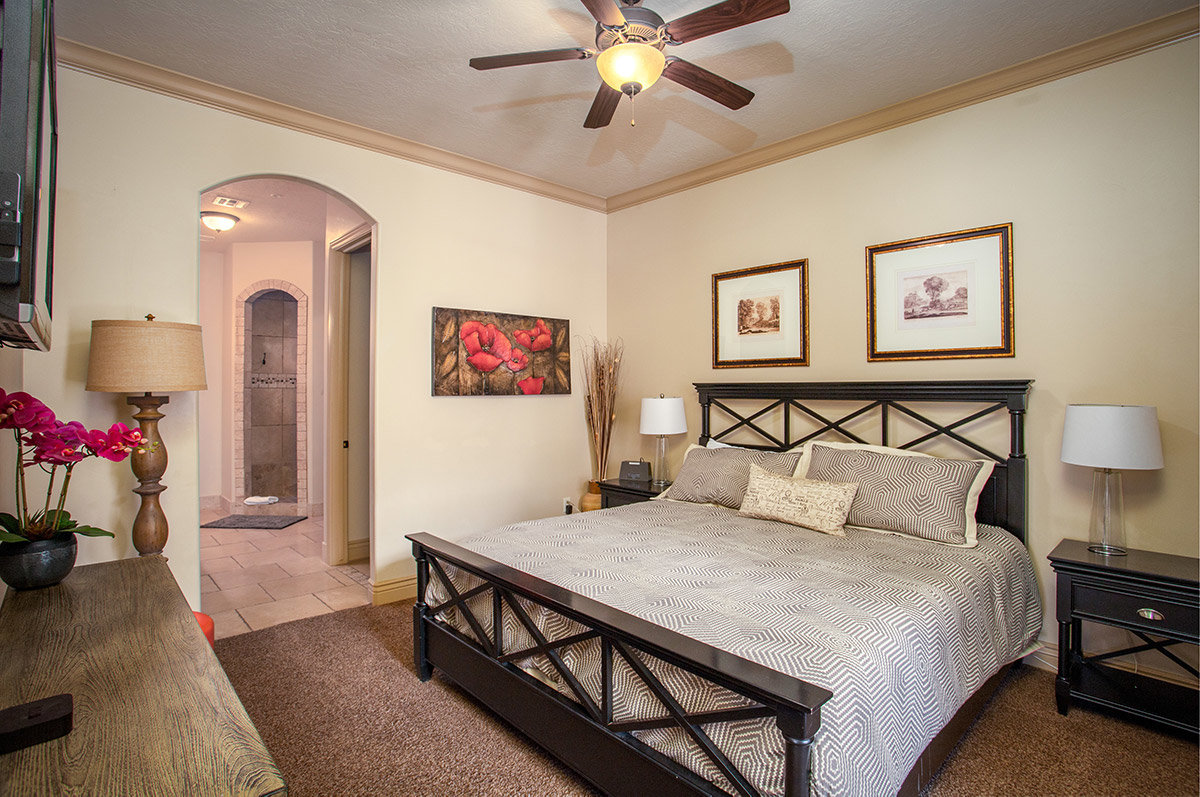 Master hotel room with bed and view into bathroom
