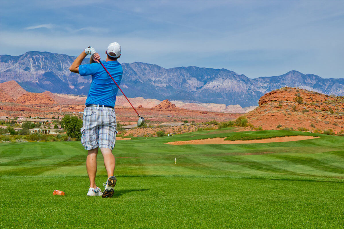 Male golfer in backswing with purple mountain in distance