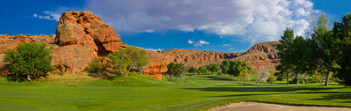 Panoramic view of desert golf course with red rocks