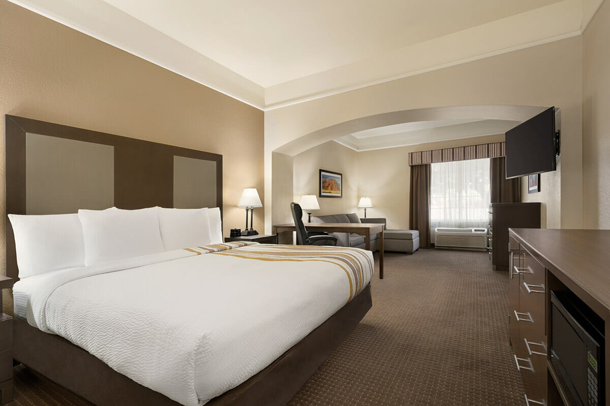 Modern hotel room with king bed and seating area