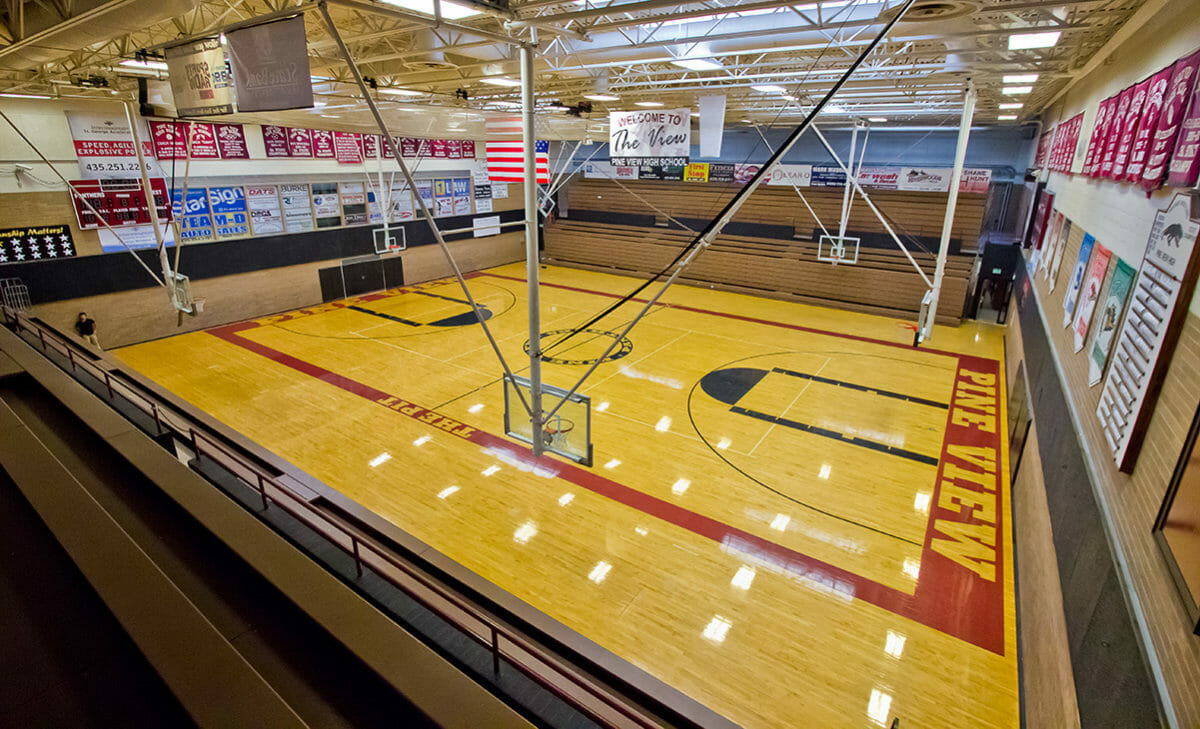 Wide view of indoor basketball court with polished wood floor