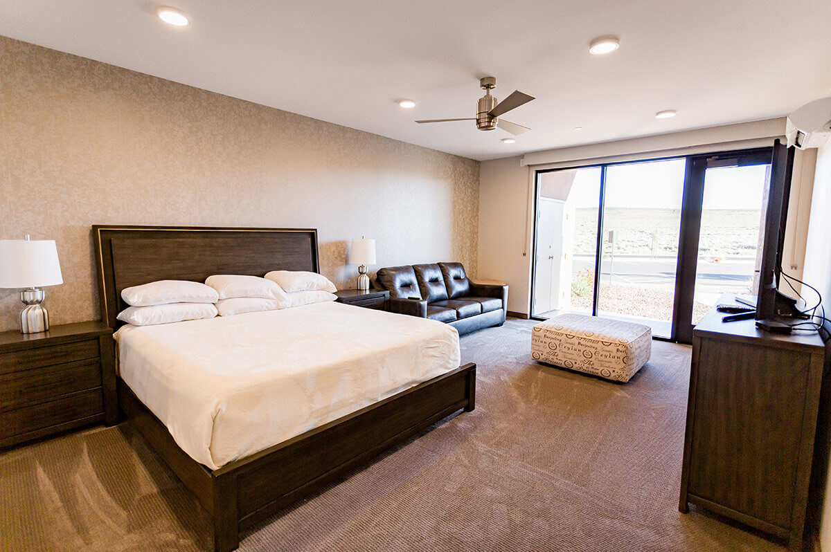 Hotel room with king size bed and leather sofa