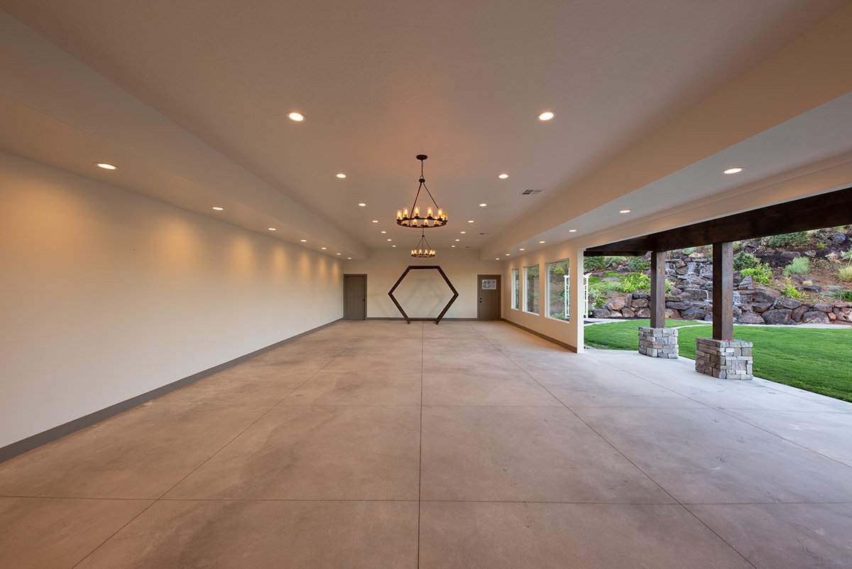 Large, modern room at event venue with open door to outdoor courtyard